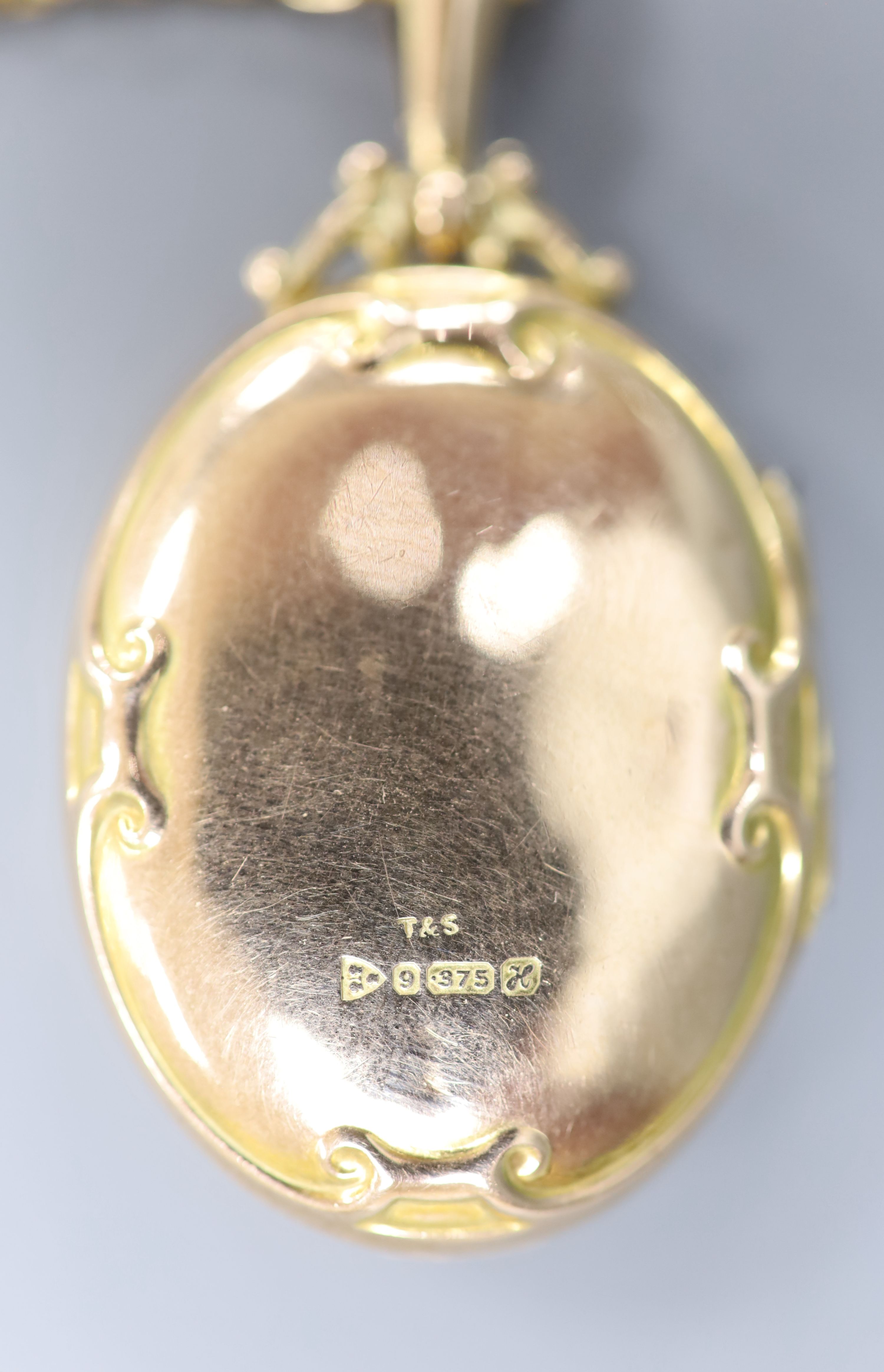 An Edwardian Art Nouveau 9ct gold oval locket, on a 9ct chain